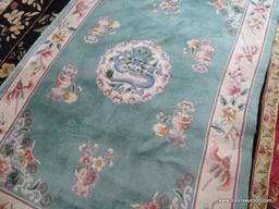 HANDMADE SCULPTED CHINESE RUG IN GREEN, IVORY, AND MAUVE WITH A DRAGON THEMED CENTER MEDALLION.