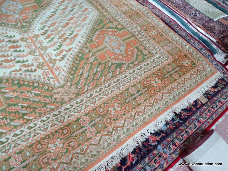 HANDMADE ORIENTAL RUG IN GREEN, ORANGE, AND IVORY. MEASURES APPROXIMATELY 8 FT 11 IN X 11 FT 9 IN.