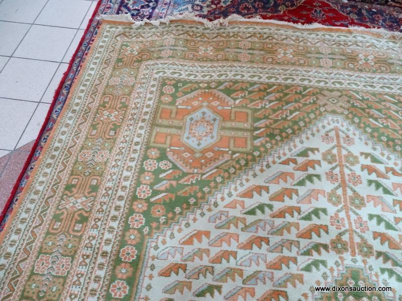 HANDMADE ORIENTAL RUG IN GREEN, ORANGE, AND IVORY. MEASURES APPROXIMATELY 8 FT 11 IN X 11 FT 9 IN.