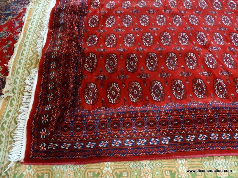 MACHINE MADE KARASTAN SILKY BOKHARA IN RED, IVORY AND BLUE. MEASURES APPROXIMATELY 8 FT X 10 FT.