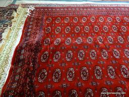 MACHINE MADE KARASTAN SILKY BOKHARA IN RED, IVORY AND BLUE. MEASURES APPROXIMATELY 8 FT X 10 FT.