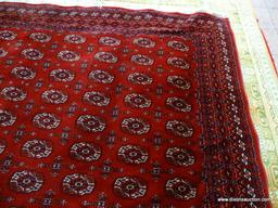 MACHINE MADE KARASTAN SILKY BOKHARA IN RED, IVORY AND BLUE. MEASURES APPROXIMATELY 8 FT X 10 FT.