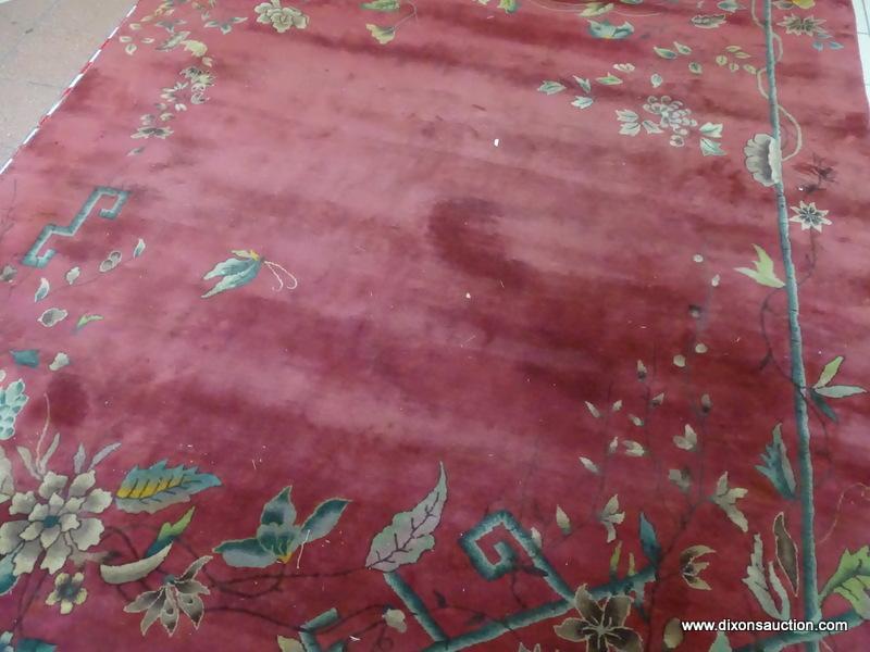 VINTAGE MACHINE MADE ORIENTAL RUG IN MAROON AND GREEN. SHOWS MOTH DAMAGE. MEASURES APPROXIMATELY 8