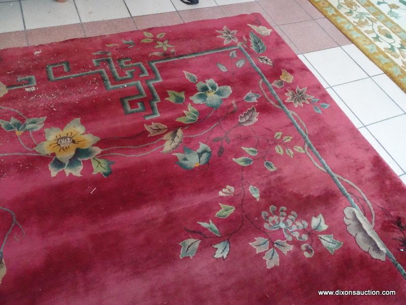 VINTAGE MACHINE MADE ORIENTAL RUG IN MAROON AND GREEN. SHOWS MOTH DAMAGE. MEASURES APPROXIMATELY 8