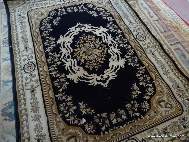 MACHINE MADE ORIENTAL STYLE RUG IN BLACK, BEIGE, AND IVORY. MEASURES APPROXIMATELY 7 FT 2 IN X 5 FT