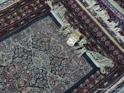 MACHINE MADE ORIENTAL STYLE RUG IN BLUE, IVORY, AND RED. MEASURES APPROXIMATELY 1 FT 7 IN X 3 FT.