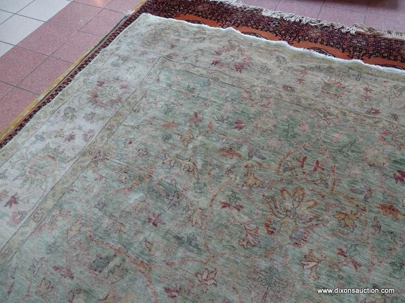 MACHINE MADE ORIENTAL AREA RUG IN GREEN, IVORY, AND GOLD. HAS A VEGETABLE DYE LOOK. MEASURES