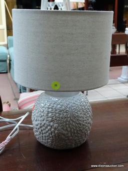 (R1) WHITE FLORAL PATTERN LAMP WITH CLOTH SHADE. MEASURES 14 IN TALL. ITEM IS SOLD AS IS WHERE IS