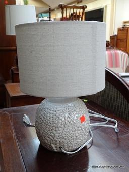 (R1) WHITE FLORAL PATTERN LAMP WITH CLOTH SHADE. MEASURES 14 IN TALL. ITEM IS SOLD AS IS WHERE IS