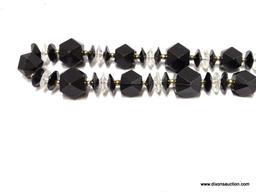 (SC) BLACK AND CLEAR PLASTIC COSTUME JEWELERY NECKLACE 24 IN LONG. ITEM IS SOLD AS IS, WHERE IS,