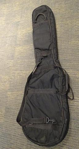 (SC) SOFT CASE GUITAR CARRYING BAG. HAS A SMALL HOLE IN THE BOTTOM OF THE CASE. ITEM IS SOLD AS IS