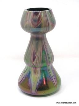 A translucent, gourd shaped green glass having surface decoration of opaque white and purple swirls.