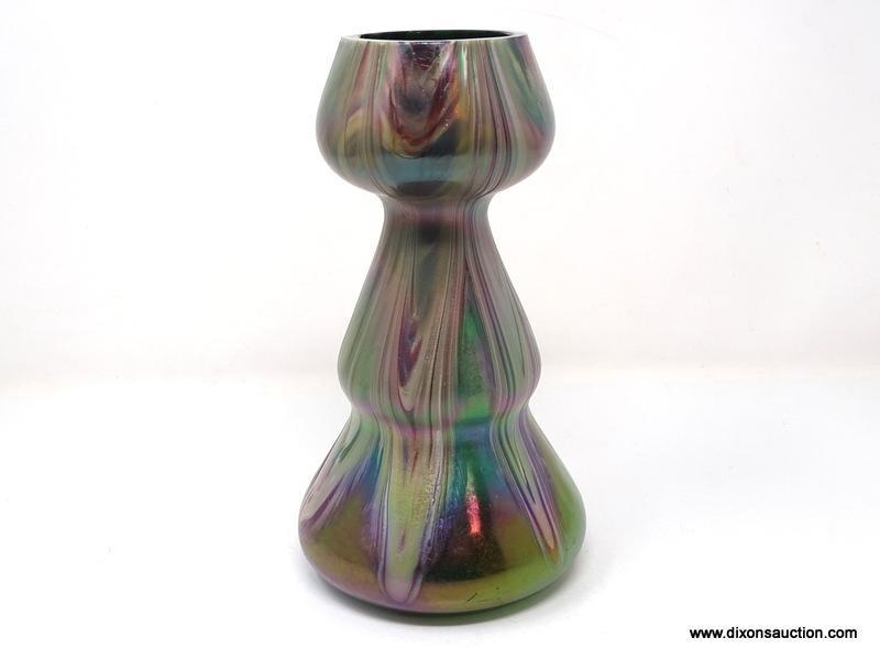 A translucent, gourd shaped green glass having surface decoration of opaque white and purple swirls.