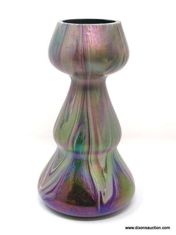 A translucent, gourd shaped green glass having surface decoration of opaque white and purple swirls.