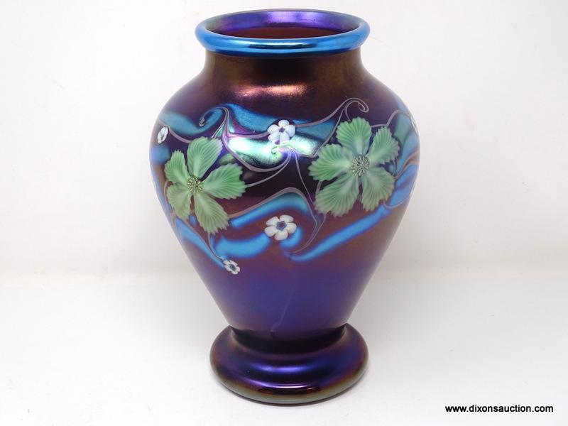 Purplish brown iridized glass with surface decoration of green and white floral motif having