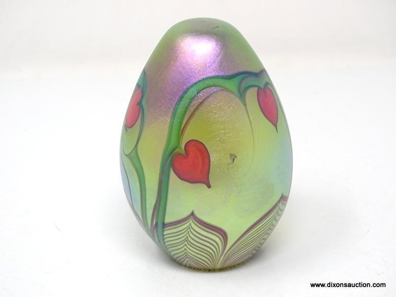 An egg shaped, translucent, gold/green surface decorated hearts & vines design with a beautifully