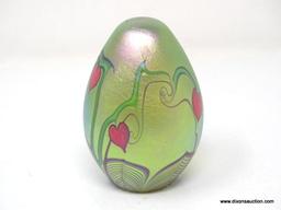 An egg shaped, translucent, gold/green surface decorated hearts & vines design with a beautifully