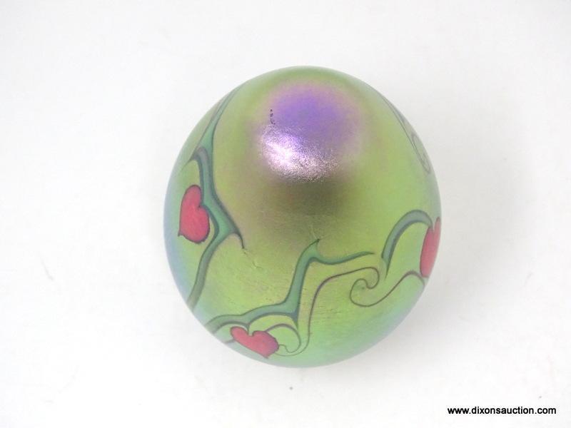 An egg shaped, translucent, gold/green surface decorated hearts & vines design with a beautifully