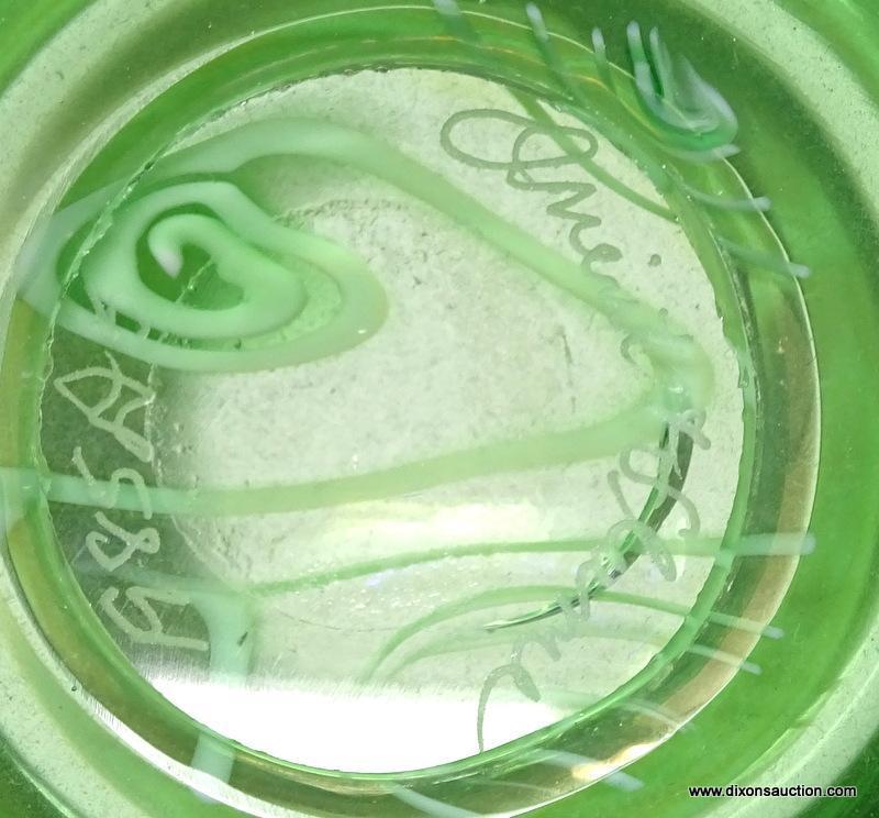 A green translucent vase with King Tut styled swirls. The rim has no lip. The shoulders flare to a