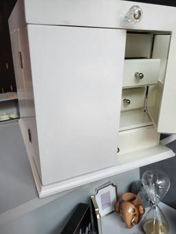 WHITE JEWELRY BOX. BOX HAS SEVERAL DRAWERS AND CUBBIES. CAN FIT A LOT OF JEWELRY. IS SOLD AS IS