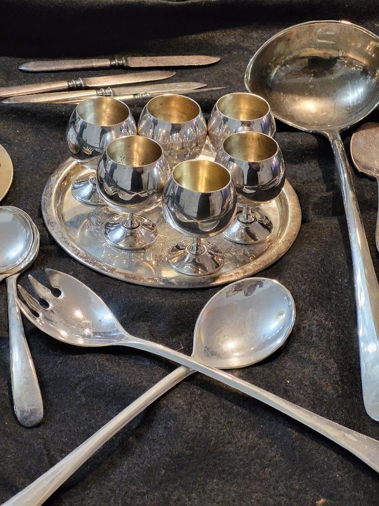 OVER 50 PIECE SILVERPLATE LOT. INCLUDES LADLES, SPOONS, FORKS, COASTERS AND MUCH MORE. IS SOLD AS IS