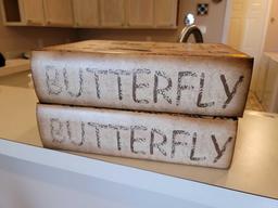 (LR) PAIR OF LARGE FAUX. BOOK DECORATIVE "BUTTERFLY" LIFT TOP STORAGE BOXES. THEY MEASURE APPROX.