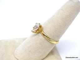 GOLD TONE ENGAGEMENT RING WITH APPROX. 1 CT. PRONG SET PEAR CUT CZ CENTER STONE. THE RING SIZE IS