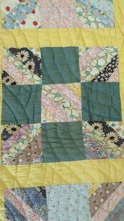 HANDMADE SQUARE PATTERN QUILT WITH A FLORAL DESIGN ON THE BACK MEASURES APPROXIMATELY 74 IN X 90 IN