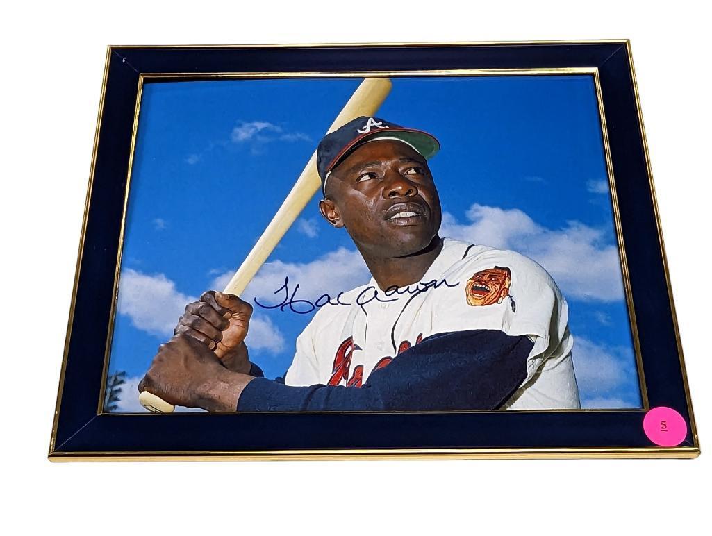 FRAMED & AUTOGRAPHED PHOTO OF HANK AARON. DISPLAYED IN A BLUE & GOLD FRAME. IT MEASURES APPROX.