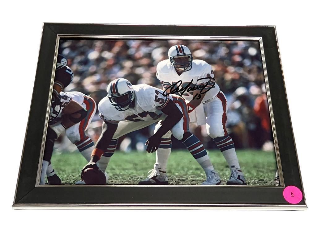 FRAMED & AUTOGRAPHED PHOTO OF DAN MARINO. DISPLAYED IN A BLACK AND SILVER FRAME. IT MEASURES APPROX.