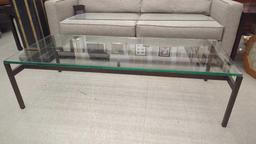 METAL AND GLASS TOP COFFEE TABLE MEASURES APPROXIMATELY 60 IN X 24 IN X 16 IN.
