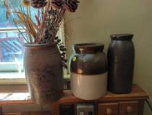 (LAUNDRY) LOT OF 3 POTTERY CROCKS. INCLUDES: A TAN SALT GLAZED CROCK WITH DRIED FLOWERS, A BROWN AND