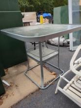 Green metal glass top bar height outdoor patio table with center umbrella hole. Used. Sold as-is.