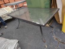 Brown metal rectangular glass top outdoor patio table with center umbrella hole. Used and does show
