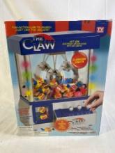 The Claw Electronic miniature claw machine. Brand new never used in original packaging.