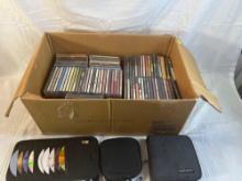 Huge lot of CDs along with two zipper storage cases and car visor CD holder