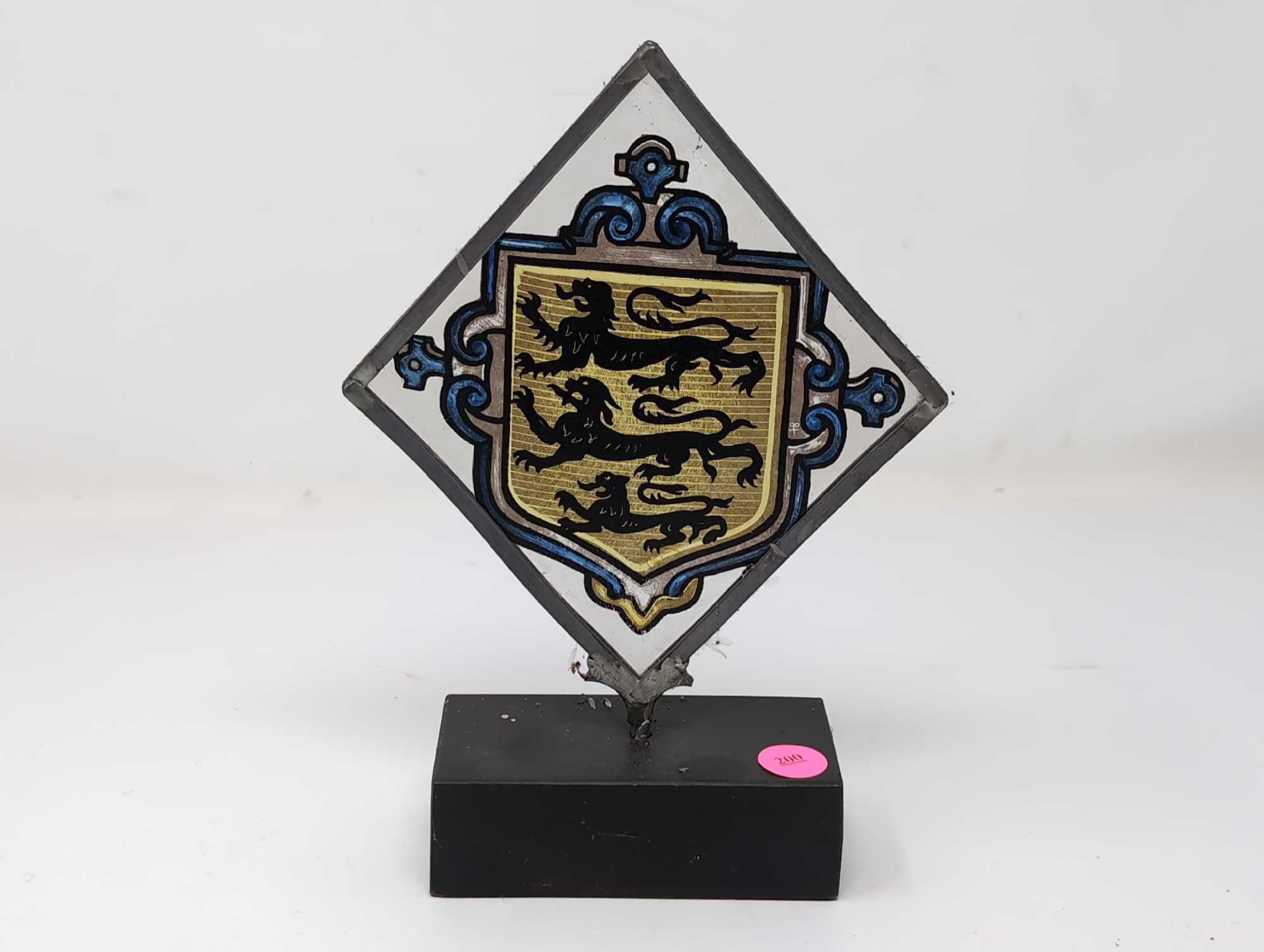 (LR) VINTAGE TRIANGULAR PAINTING ON GLASS DEPICTING A THREE LION CREST. THE GLASS IS FRAMED IN A