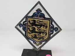 (LR) VINTAGE TRIANGULAR PAINTING ON GLASS DEPICTING A THREE LION CREST. THE GLASS IS FRAMED IN A