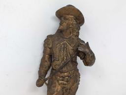 (LR) ANTIQUE SPELTER VICTORIAN MUSKETEER CLOCK FIGURINE. GOLD TONED. DOES SHOW SOME WEAR CONSISTENT