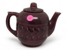 SIGNED USA BURGUNDY GLAZED CERAMIC TEA POT WITH LID & RAISED DETAILING. IT MEASURES APPROX. 7" X 4"