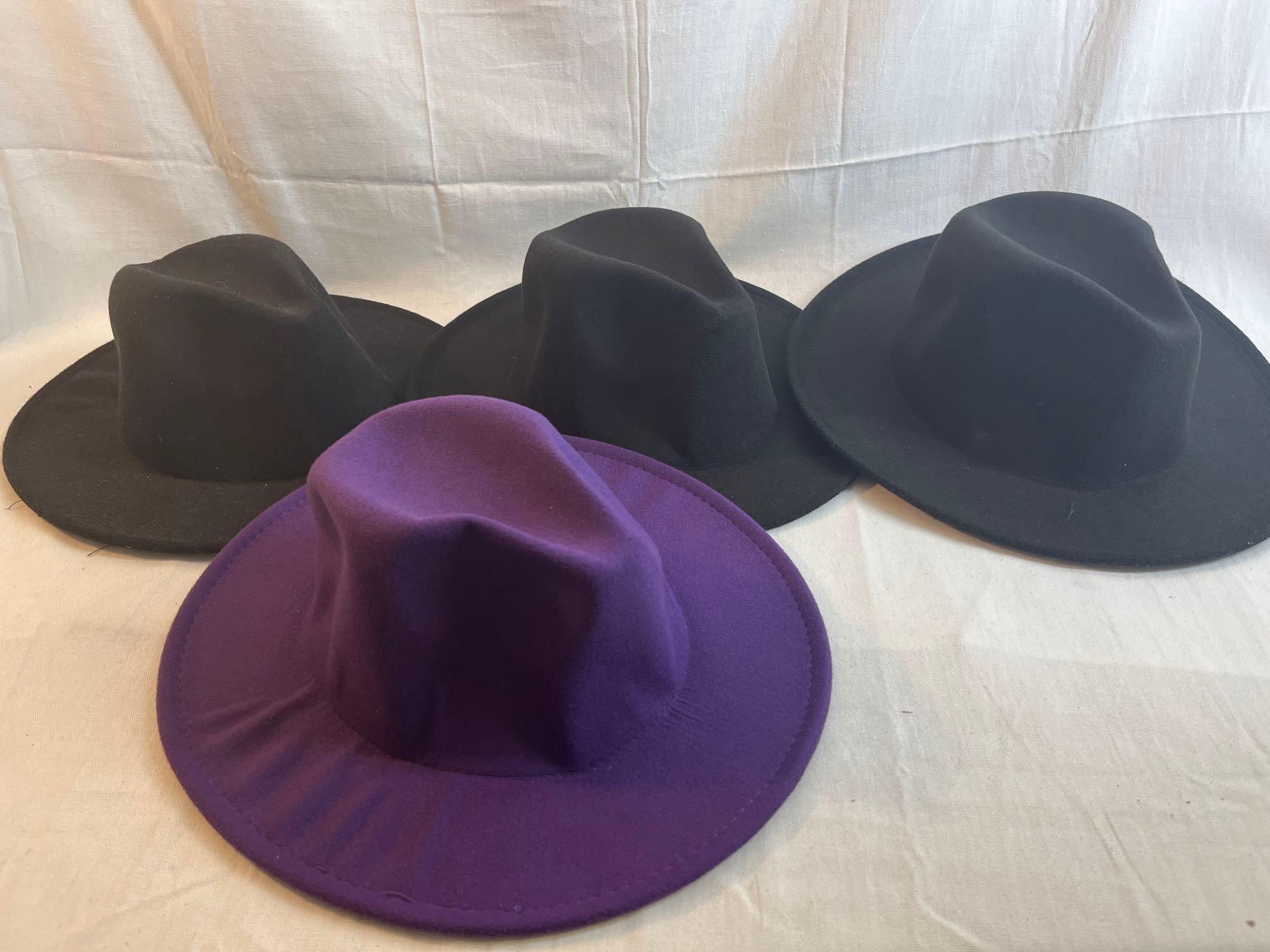 Lot of four wide brimmed hats. One purple with yellow inside, three black with red inside....