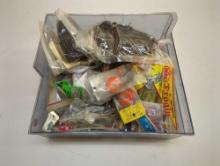 Gray container and contents including worms, various fishing lures, and other fishing accessories.