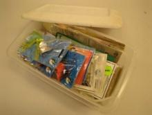 White Sterilite organizer tote filled with packaged fishing lures. Comes as is shown in photos.