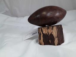 DARK WOOD CARVED FOOTBALL MOUNTED ON BRANCH