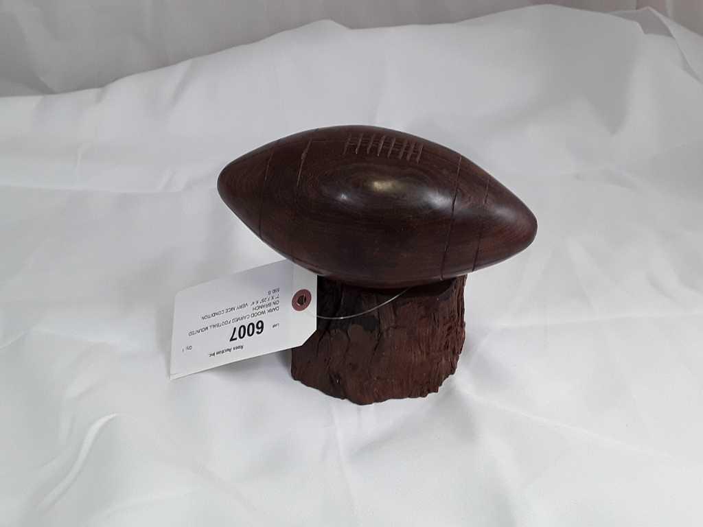 DARK WOOD CARVED FOOTBALL MOUNTED ON BRANCH