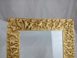 GOLD GILDED FRAME WITH CHERUBS AROUND IT.