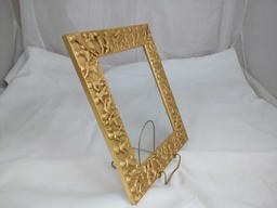 GOLD GILDED FRAME WITH CHERUBS AROUND IT.