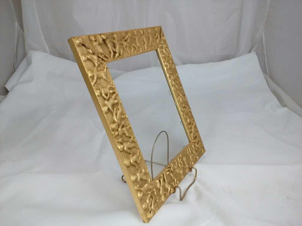 GOLD GILDED FRAME WITH CHERUBS AROUND IT.