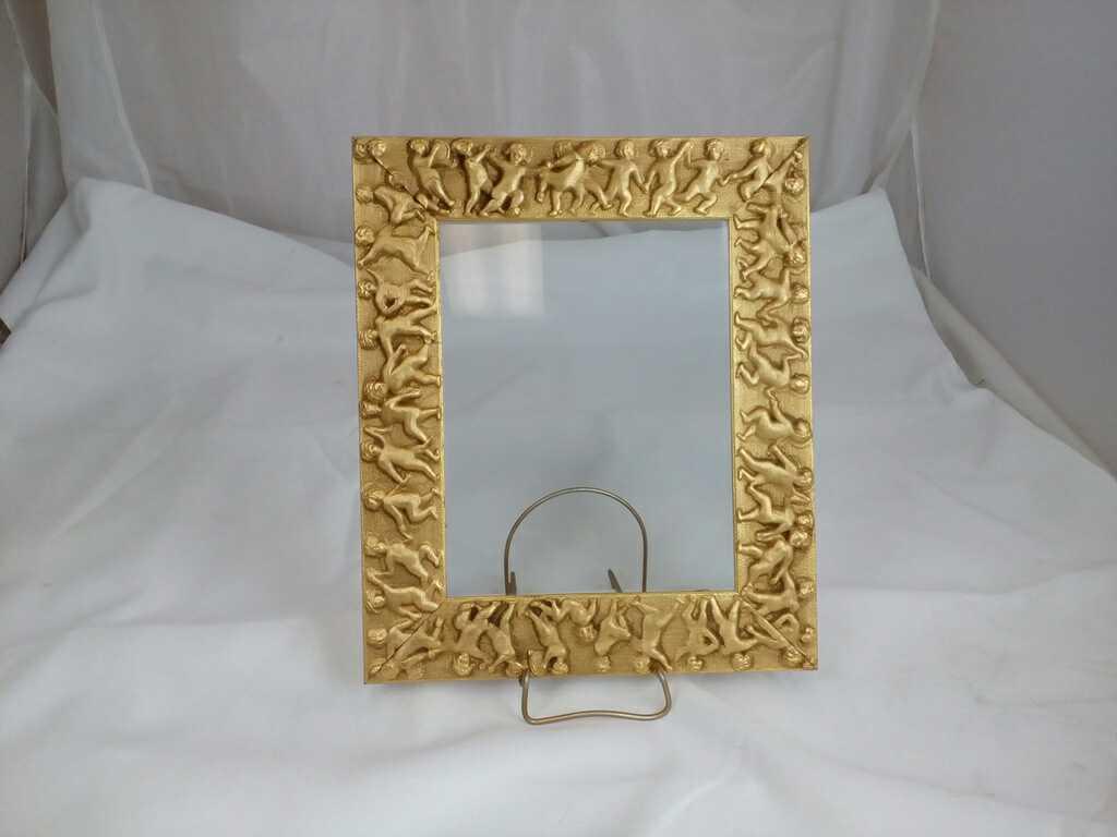 GOLD GILDED FRAME WITH CHERUBS AROUND IT.