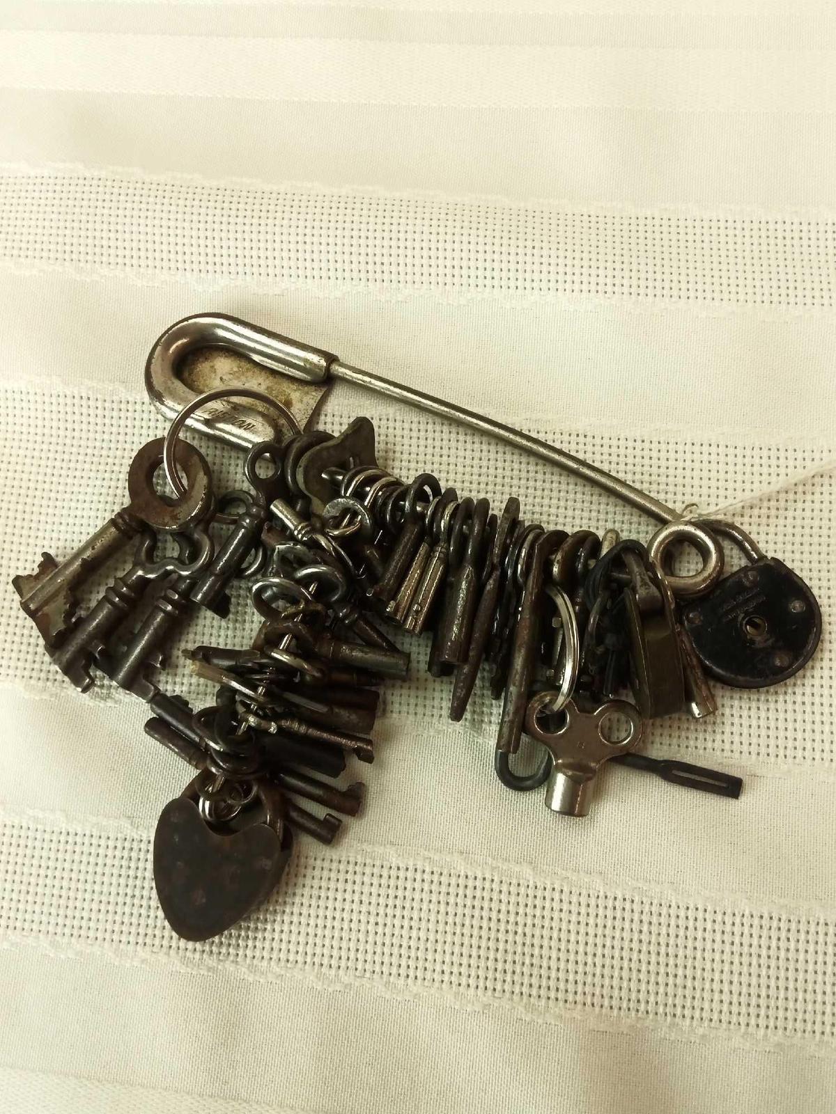 ASSORTED VINTAGE SKELETON KEYS AND LOCKS ON LARGE SAFETY PIN